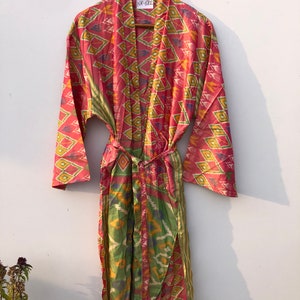 May include: A pink and green patterned silk robe with a tie belt. The robe has a tag that says "NK-682".