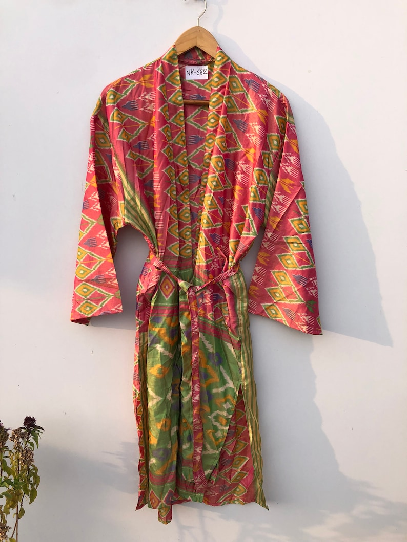 May include: A pink and green patterned silk robe with a tie belt. The robe has a tag that says "NK-682".