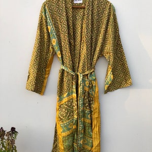 May include: A green and gold patterned silk robe with a tie belt. The robe has a label that says "NK-688".