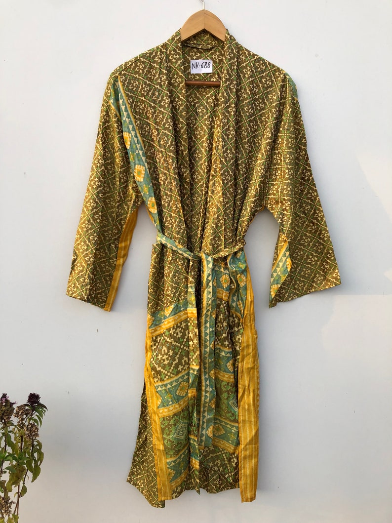 May include: A green and gold patterned silk robe with a tie belt. The robe has a label that says "NK-688".