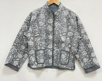 Könnte beinhalten: Graue Steppjacke mit floralem Muster und zwei Vordertaschen. Die Jacke hat einen Stehkragen und hängt an einem Holzbügel. Die Jacke ist etwa 64 cm lang.