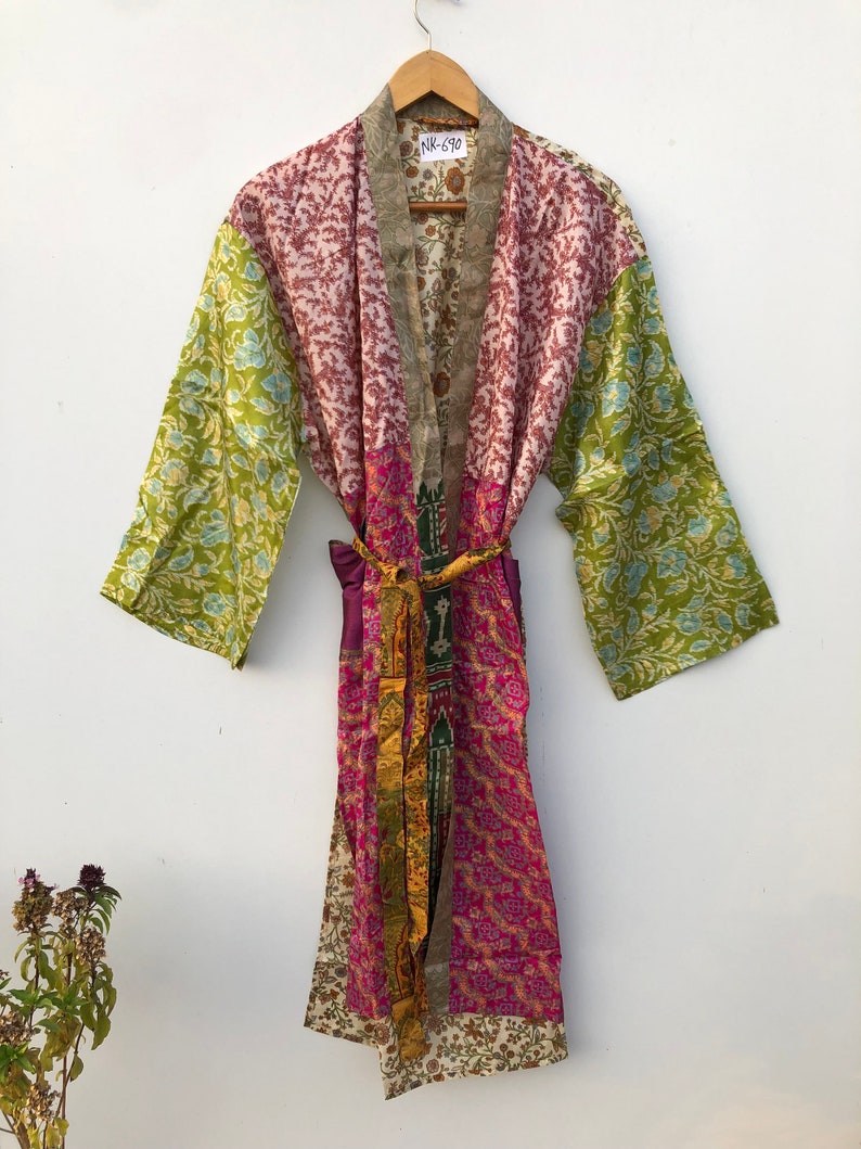 May include: A multi-colored silk robe with a patchwork design. The robe has a green, pink, and white floral pattern. The robe has a purple sash and a tag that says "NK-610".