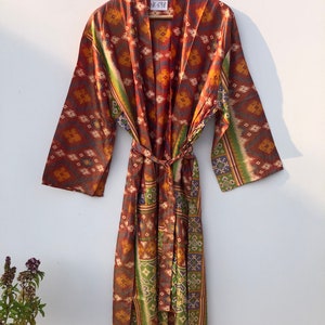 May include: A long, brown silk robe with a colorful geometric pattern. The robe has a tie belt and long sleeves. The tag on the robe says "UK-698".