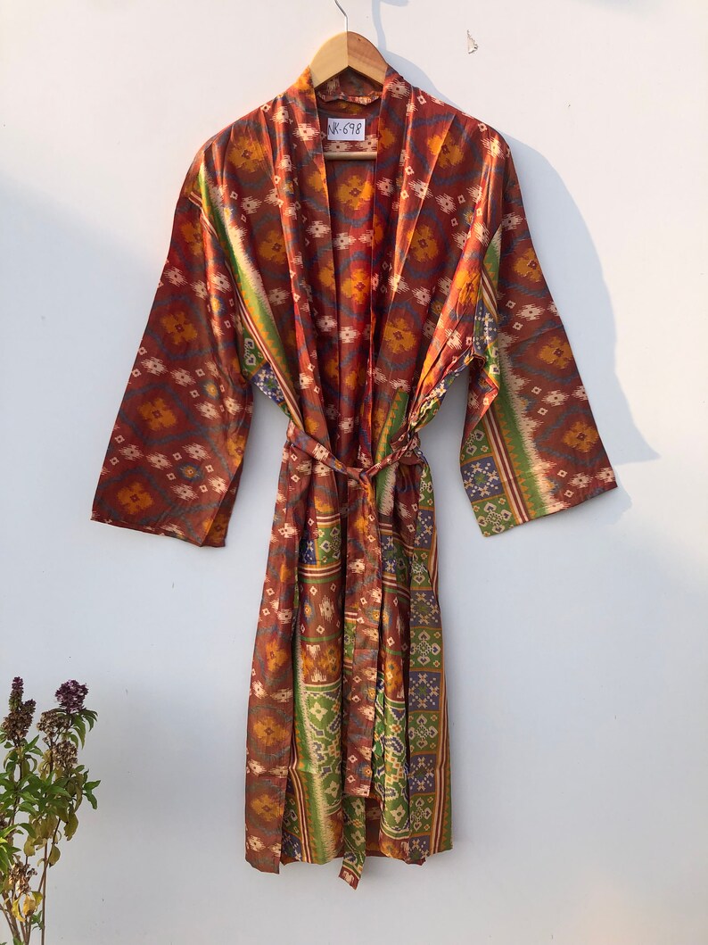 May include: A long, brown silk robe with a colorful geometric pattern. The robe has a tie belt and long sleeves. The tag on the robe says "UK-698".