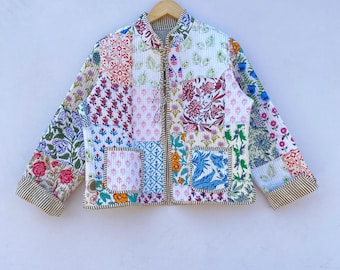 May include: A white quilted jacket with a patchwork design featuring various floral patterns in shades of pink, blue, green, and red. The jacket has a zipper closure and a mandarin collar.