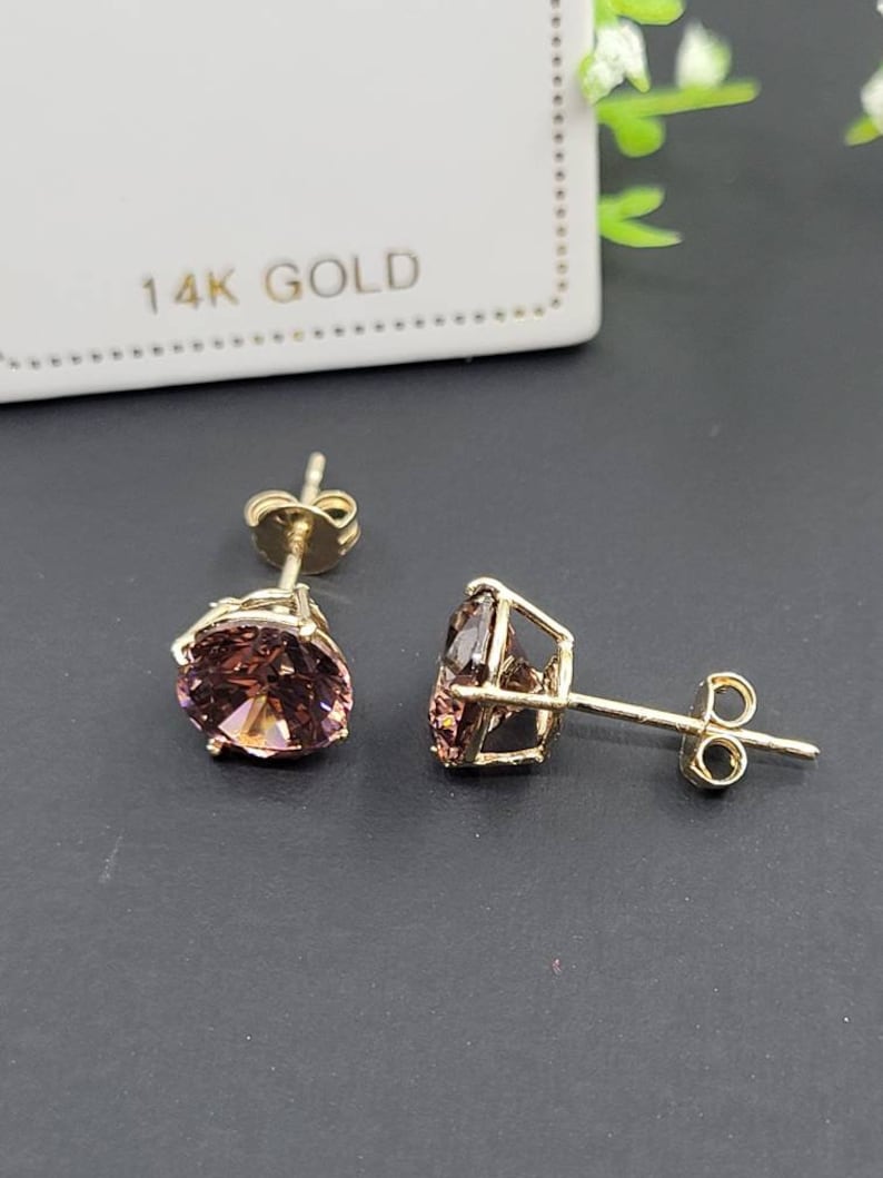 Peut inclure: Une paire de boucles d'oreilles en or 14 carats avec une pierre pr&eacute;cieuse ronde rose dans chaque boucle d'oreille.