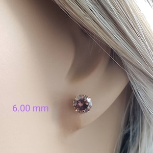Peut inclure: Une paire de boucles d'oreilles en or avec une pierre ronde de couleur violette fonc&eacute;e de 6,00 mm de diam&egrave;tre.