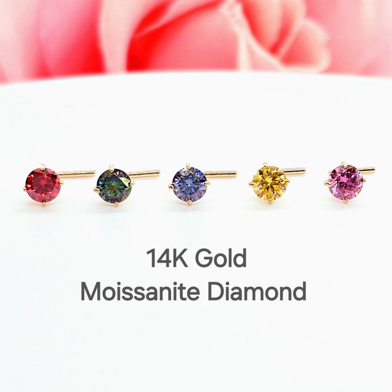 K&ouml;nnte beinhalten: F&uuml;nf 14 Karat Gold Nasenringe mit verschiedenen runden Moissanit-Diamanten in verschiedenen Farben. Die Diamanten sind rot, gr&uuml;n, blau, gelb und pink.