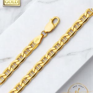 Pode incluir: Um colar de corrente dourada com um design de elos de marinheiro. O colar é feito de ouro 14K e possui um fecho lagosta. A corrente é exibida em uma superfície de mármore branco. A imagem também inclui o texto "14K GOLD".