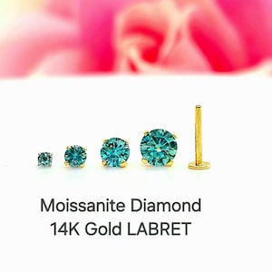May include: Four sizes of labret studs with a teal blue moissanite diamond and 14k gold setting. Moissanite Diamond 14K Gold LABRET.