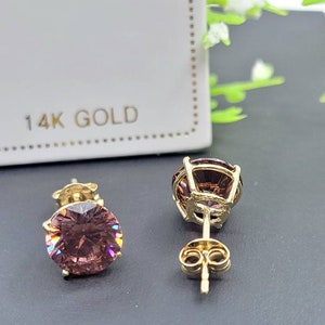 Peut inclure: Une paire de boucles d'oreilles en or 14 carats avec une pierre pr&eacute;cieuse ronde rose dans chaque boucle d'oreille. Les boucles d'oreilles ont un fermoir &agrave; tige et papillon.
