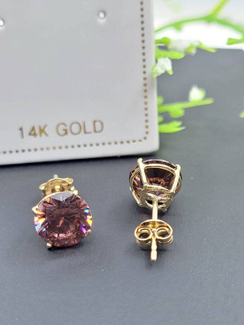 Peut inclure: Une paire de boucles d'oreilles en or 14 carats avec une pierre pr&eacute;cieuse ronde rose dans chaque boucle d'oreille. Les boucles d'oreilles ont un fermoir &agrave; tige et papillon.