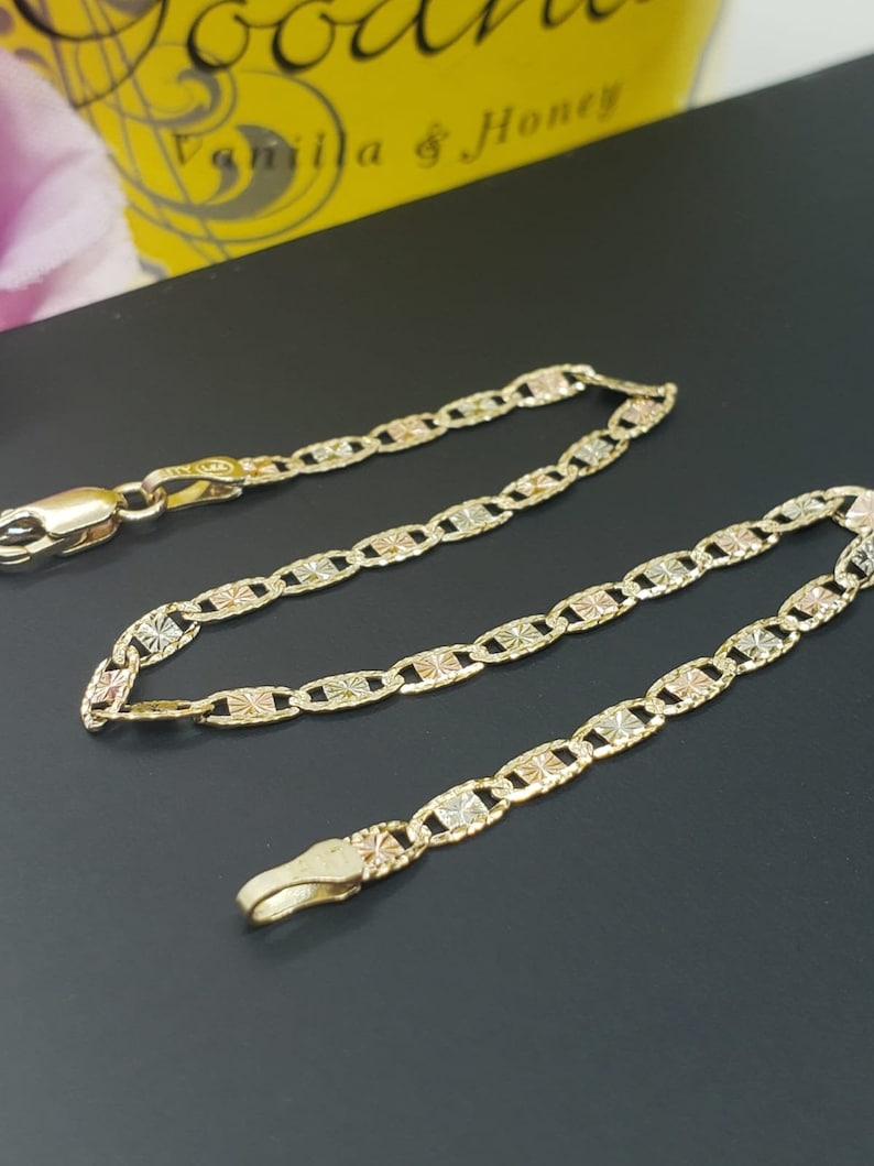 Puede incluir: Un collar de cadena de oro con un dise&ntilde;o tricolor. La cadena est&aacute; hecha de tres tonos de oro diferentes: amarillo, rosa y blanco. La cadena est&aacute; hecha de peque&ntilde;os eslabones entrelazados.