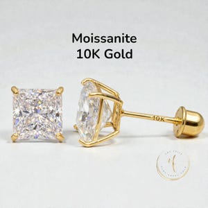 Op de afbeelding: Een paar radiant-cut moissanite oorstekers in 10K goud. De oorbellen hebben een vierkante, heldere edelsteen gezet in een vier-klauwzetting. De tekst "Moissanite 10K Gold" staat boven de oorbellen.