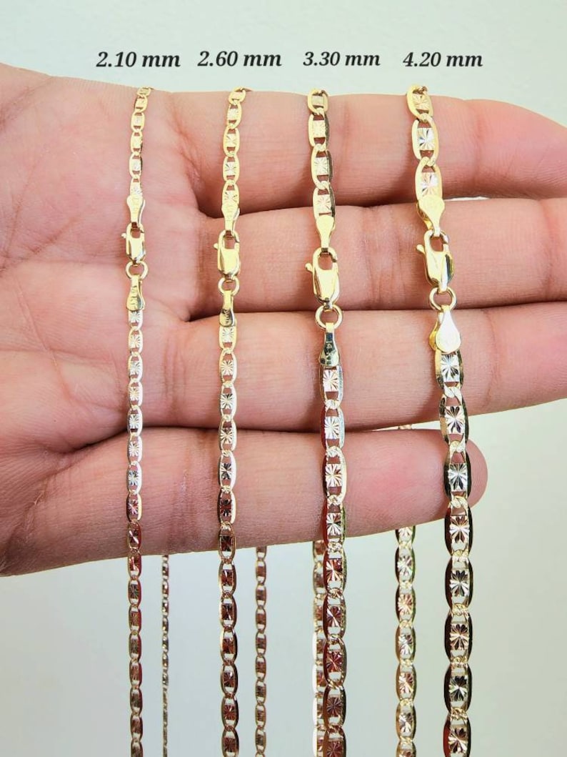 May include: Four gold chains of different widths, 2.10 mm, 2.60 mm, 3.30 mm, and 4.20 mm, are shown in a hand. The chains are all made of a delicate, patterned design.