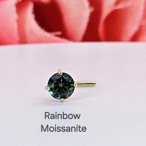 K&ouml;nnte beinhalten: Ein goldener Nasenring mit einem runden, gr&uuml;nen und blauen Moissanit-Stein. Der Stein hat einen Regenbogeneffekt. Der Text "Rainbow Moissanite" befindet sich unter dem Ring.