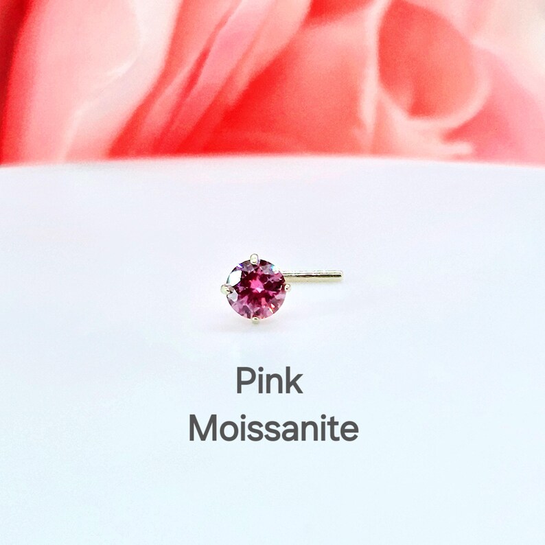 K&ouml;nnte beinhalten: Ein Nasenring aus rosa Moissanit mit einem goldenen Stift.