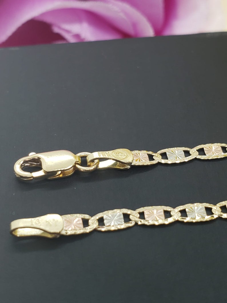 Puede incluir: Un collar de cadena de oro con un dise&ntilde;o tricolor. La cadena est&aacute; hecha de oro amarillo, blanco y rosa. La cadena tiene un cierre de langosta.