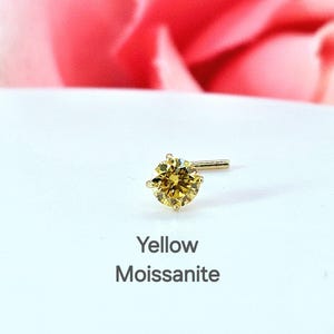 K&ouml;nnte beinhalten: Ein gelber Moissanit-Nasenring mit einer goldenen Fassung. Der Ring befindet sich auf einem wei&szlig;en Hintergrund mit den Worten "Yellow Moissanite" darunter.