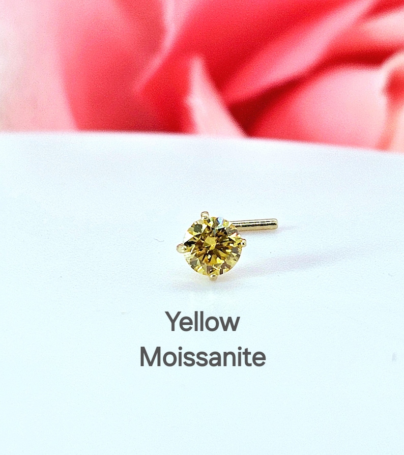 K&ouml;nnte beinhalten: Ein gelber Moissanit-Nasenring mit einer goldenen Fassung. Der Ring befindet sich auf einem wei&szlig;en Hintergrund mit den Worten "Yellow Moissanite" darunter.