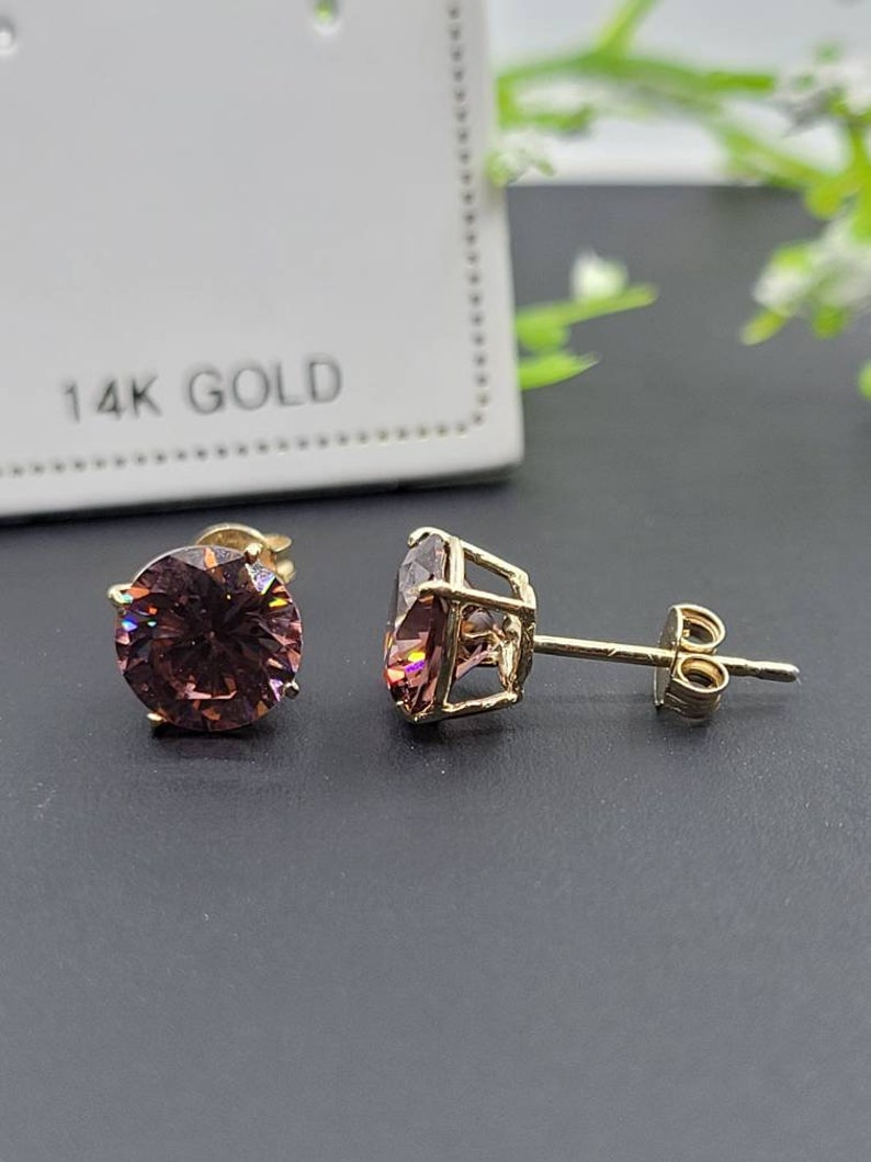 Peut inclure: Une paire de boucles d'oreilles en or 14 carats avec des pierres pr&eacute;cieuses rondes roses. Les boucles d'oreilles ont un fermoir &agrave; tige et papillon.