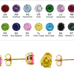 May include: A pair of gold stud earrings with a choice of gemstones. The earrings are shown with a pink and a yellow gemstone. The gemstones are available in a variety of colors, including red, purple, blue, green, and black.