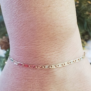 Puede incluir: Un brazalete de cadena de oro con un dise&ntilde;o delicado y estampado. El brazalete est&aacute; hecho de tres tonos diferentes de oro, creando un look &uacute;nico y elegante.
