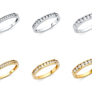 Könnte beinhalten: Drei Ewigkeitsringe mit einer Reihe runder, klarer Steine. Die Ringe sind in drei verschiedenen Metalloberflächen gezeigt: Silber, Weißgold und Gelbgold.