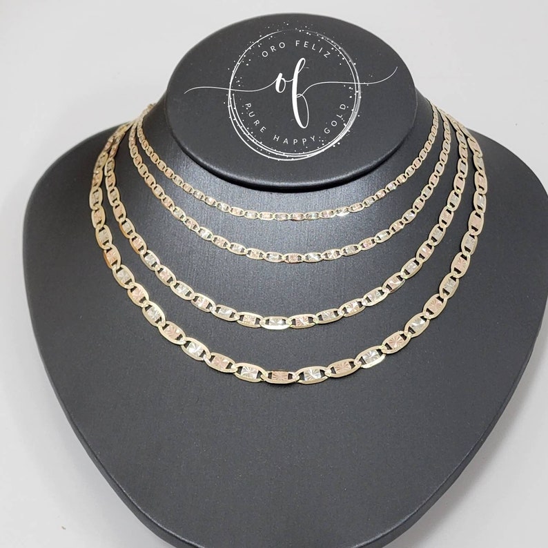 May include: Four gold chains of different lengths, all with a mariner link pattern, displayed on a black mannequin bust. The chains are made of tri-color gold, with yellow, white, and rose gold links.
