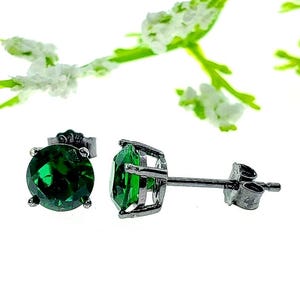 May include: A pair of silver stud earrings with a round, green gemstone in each. The earrings have a simple, classic design.