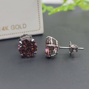 Peut inclure: Une paire de boucles d'oreilles en or 14 carats avec des pierres rondes de couleur violette serties &agrave; griffes.
