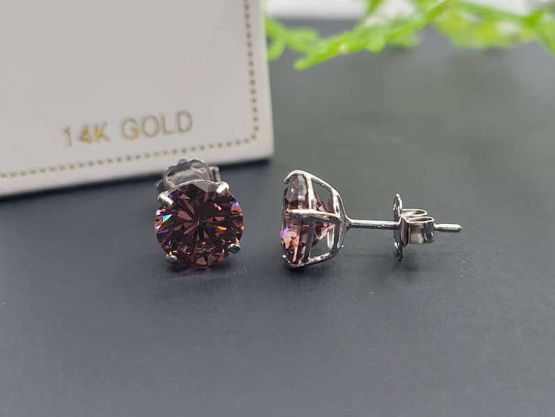 Peut inclure: Une paire de boucles d'oreilles en or 14 carats avec des pierres rondes de couleur violette serties &agrave; griffes.