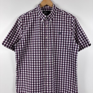 Op de afbeelding: Een overhemd met korte mouwen en een paars-wit vichy-ruitpatroon. Het overhemd is voorzien van een button-down kraag, een knoopsluiting aan de voorzijde en een klein, donker geborduurd lauwerkranslogo op de linkerborst.