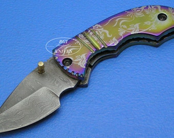May include: A rainbow-colored pocket knife with a floral pattern etched into the handle and a Damascus steel blade.