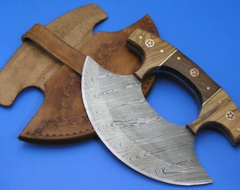 Op de afbeelding: Een gebogen mes van damaststaal met een houten handvat en messing accenten. Het mes heeft een leren schede met decoratieve stiksels.