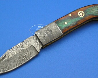 May include: A folding pocket knife with a Damascus steel blade and a wooden handle with brass accents. The handle is a mix of brown, green, and red colors.