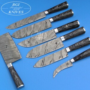 Può includere: Sette coltelli diversi con lame in acciaio Damasco e manici in legno nero. I coltelli sono numerati da 1 a 7. I coltelli sono disposti in fila su uno sfondo blu. BGI Handcrafted USA Knives.