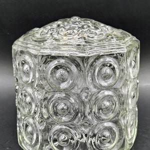 May include: A clear glass lampshade with a hexagonal shape and a textured surface of concentric circles.