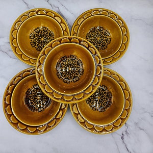 Puede incluir: Conjunto de cinco cuencos de cerámica marrón con diseños florales negros. Los cuencos tienen un borde festoneado y están dispuestos en círculo.