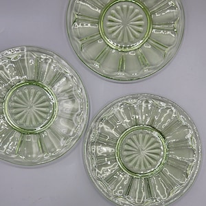 Può includere: Tre piattini vintage in vetro verde con bordo smerlato e un design a raggiera rialzato al centro.