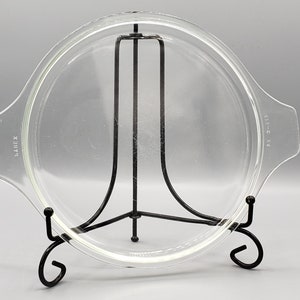 May include: A clear glass lid with a black metal stand. The lid has a raised edge and is marked "LAMBEX" and "SIZE-C 6.5".
