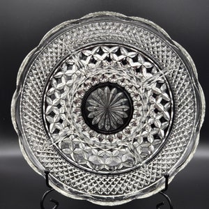 May include: A clear glass serving dish with a diamond pattern and five sections. The dish is on a black stand.