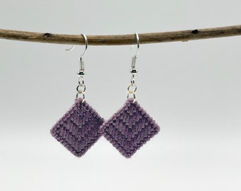May include: A pair of purple diamond-shaped earrings with silver hooks.