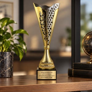 May include: A gold and silver trophy cup featuring a textured, perforated design and a leaf-like pattern. The base is black with a gold plate displaying the text: YOUR ENGRAVING UP TO 4 LINES OF PERSONALIZED TEXT CUSTOMIZE NOW!