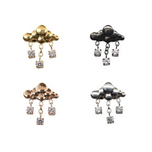 Peut inclure: Quatre boucles d'oreilles en forme de nuage avec des pierres carrées pendantes. Les boucles d'oreilles sont en or, or rose, argent et finitions en métal noir. Les pierres précieuses semblent claires et scintillantes.