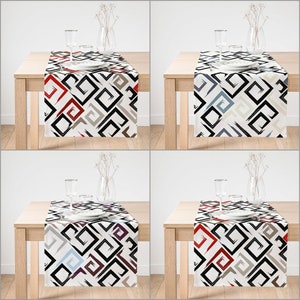 May include: Four table runners with a geometric pattern in black, white, gray, and beige. The runners feature a repeating pattern of squares and swirls in red, blue, and purple.