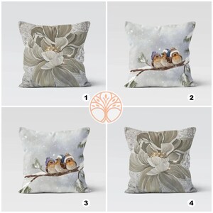 Four different throw pillow designs featuring wintery scenes. One pillow has a white flower with gold accents, another has a snowy scene with three birds, and the other two pillows have a combination of the two designs.