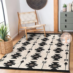 May include: Black and white geometric rug with a repeating arrow pattern. The rug has a fringe border and is laid out on a wooden floor.