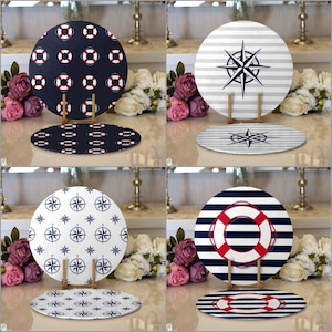 May include: Four decorative charger plates with nautical themes. The plates feature a compass, a life preserver, and stripes in red, white, and blue.