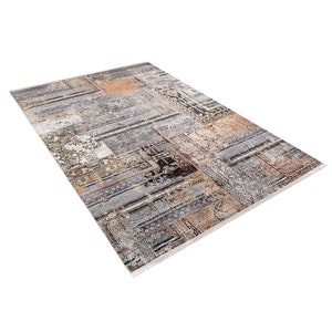 May include: A rectangular area rug with a patchwork design featuring various shades of gray, brown, and beige. The rug has a distressed, vintage look and is made of a soft, durable material.